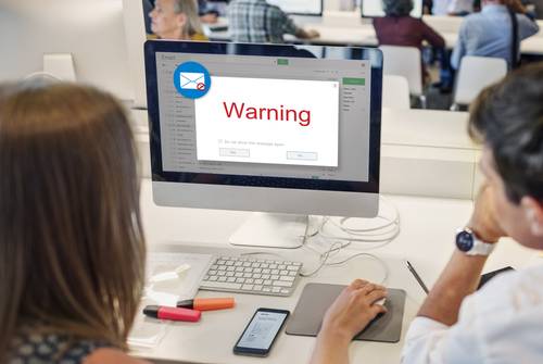 teachers looking at a warning sign on computer