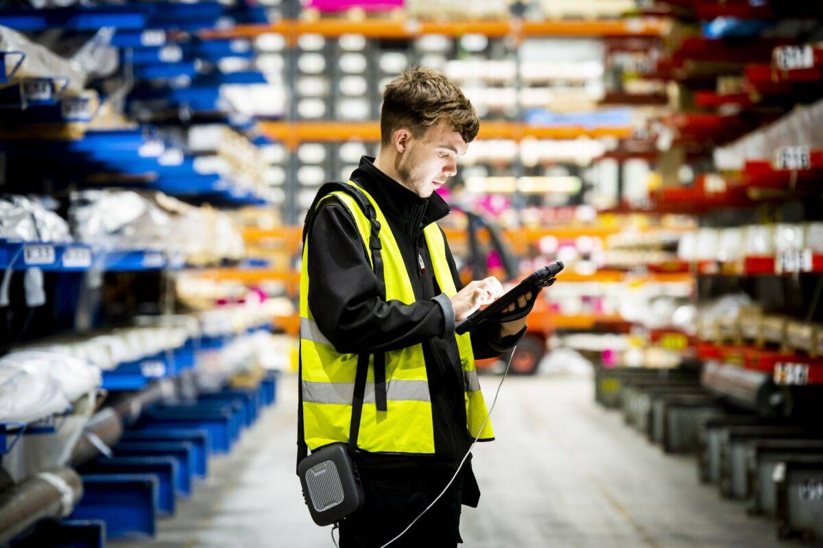 Man conducting a wifi survey in a warehouse with a tablet device